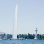 white lighthouse beside body of water during daytime