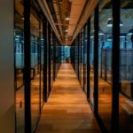 glass paneled long wooden floored hallway