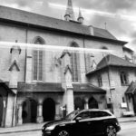a black car parked in front of a church